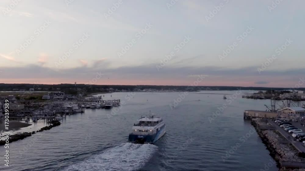 Aerial of Rhode Island pier with a ferry heading into dock at sunset.