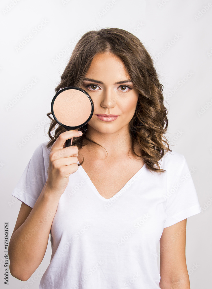 Young girl holding magnifier over her skin face skincare concept Young girl holding magnifier over her skin face skincare concept