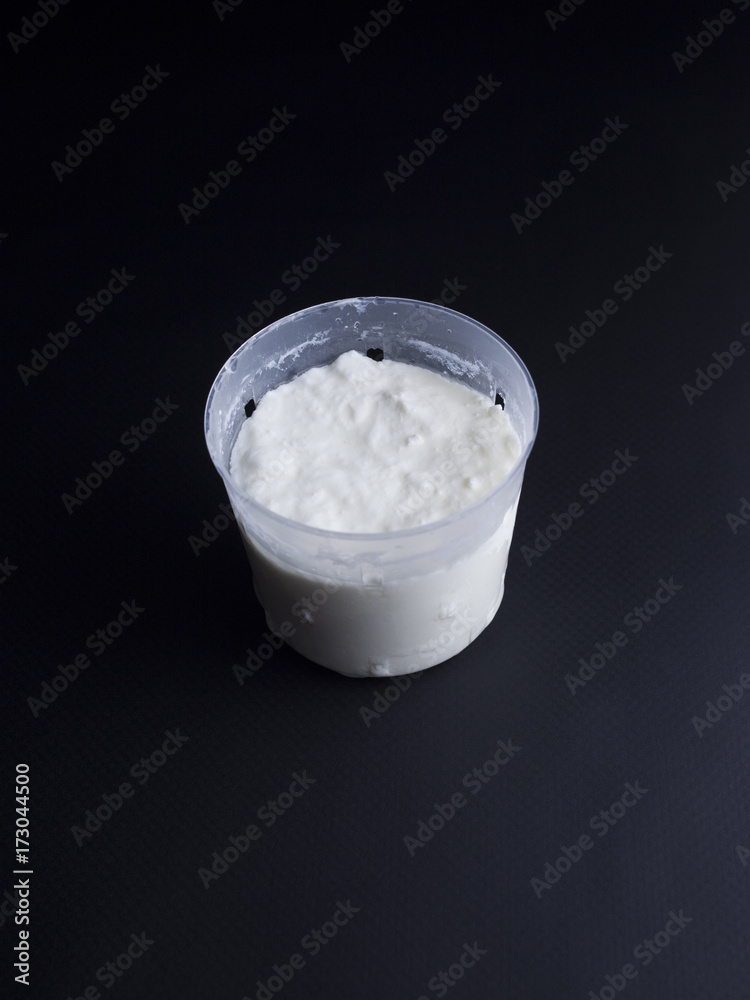 French fromage blanc (fresh cheese) in small portion sized cheese basket isolated on black background French fromage blanc (fresh cheese) in small portion sized cheese basket isolated on black background