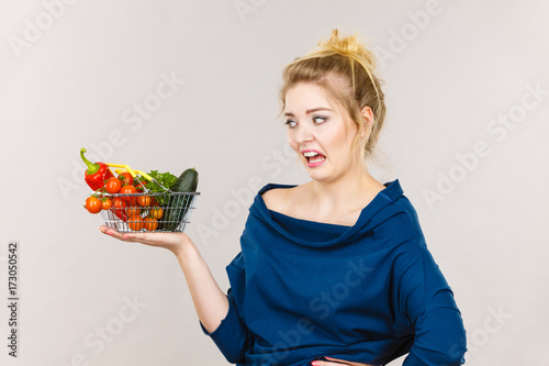 Woman with vegetables, negative face expression photo