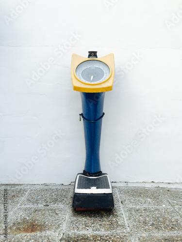 Weighing device outside against a wall photo