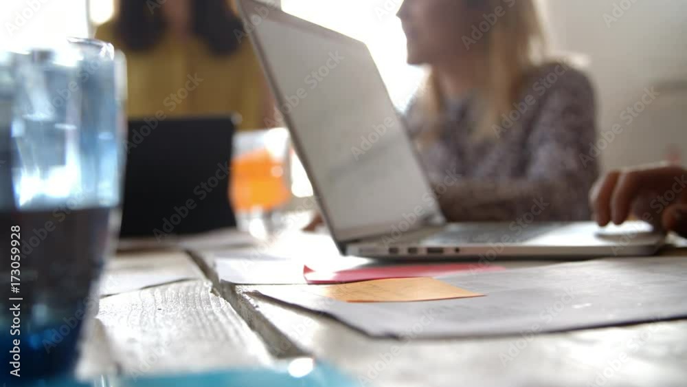 Designers Meeting Around Table With Laptop In Foreground Designers Meeting Around Table With Laptop In Foreground