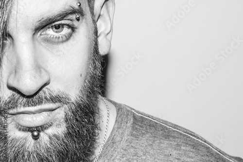 black and white portrait of a beautiful young man with a beard and piercing photo