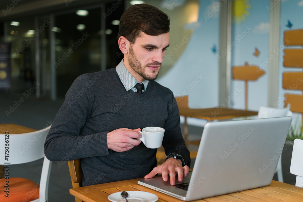 Young Businessman Working in a Cafe Young Businessman Working in a Cafe