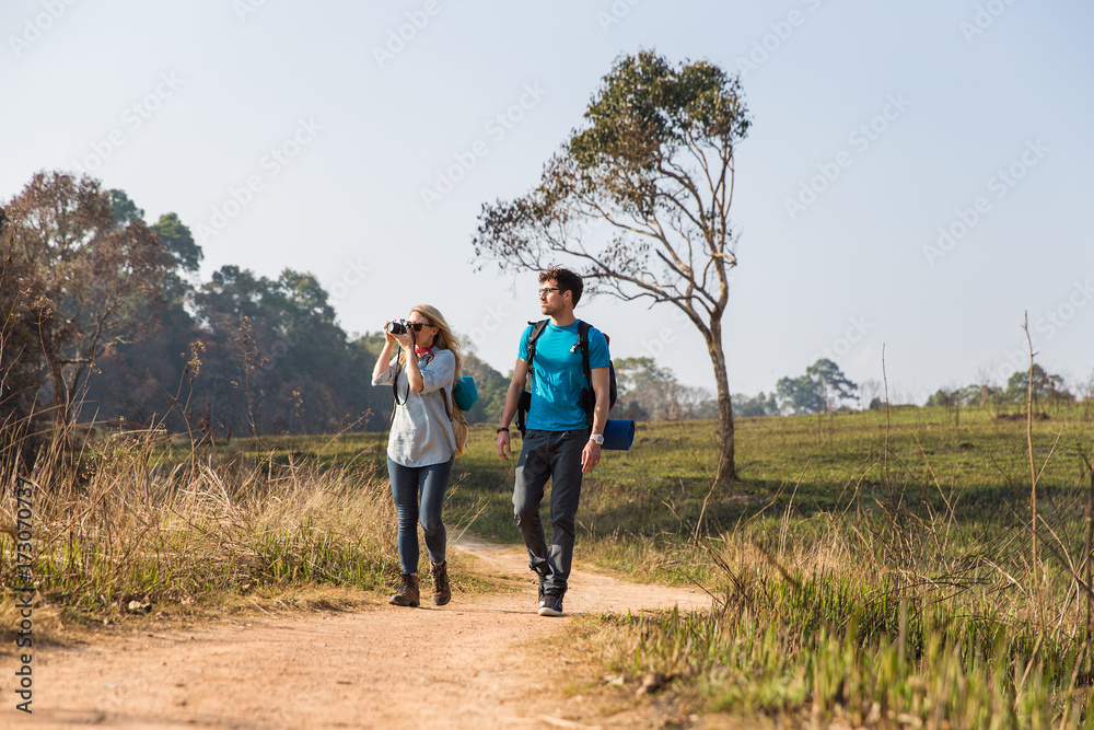 Couple walking with backpacks outdoors - adventure, travel, tourism Couple walking with backpacks outdoors - adventure, travel, tourism