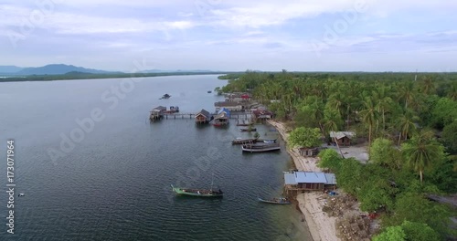 Small Fishing Village and Longtail Boats on Remote Thai Island, Ascending Pullback 
 photo