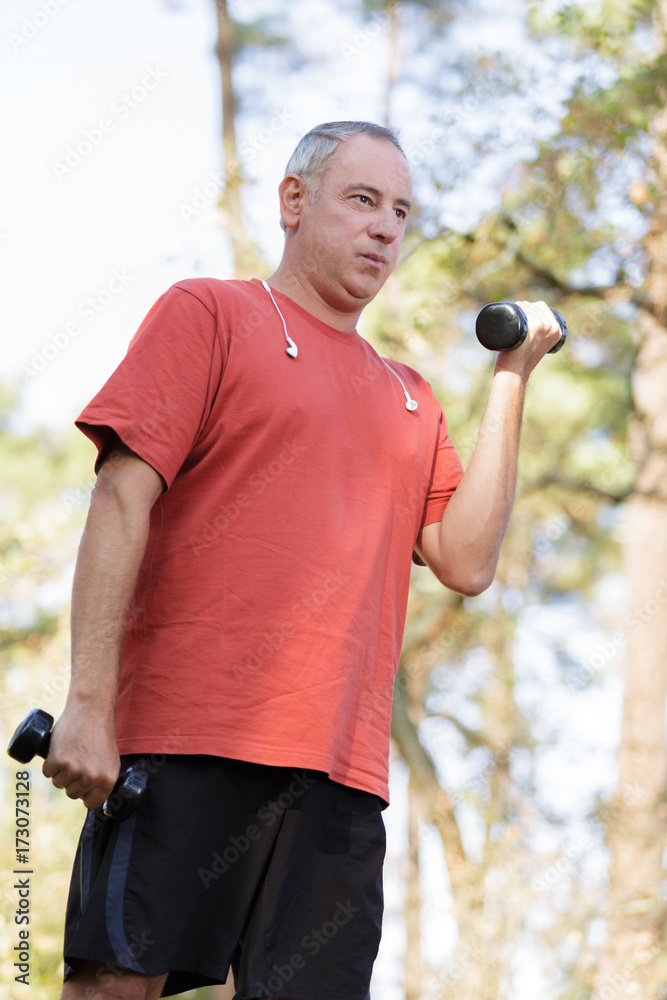 a senior man lifting dumbbells a senior man lifting dumbbells