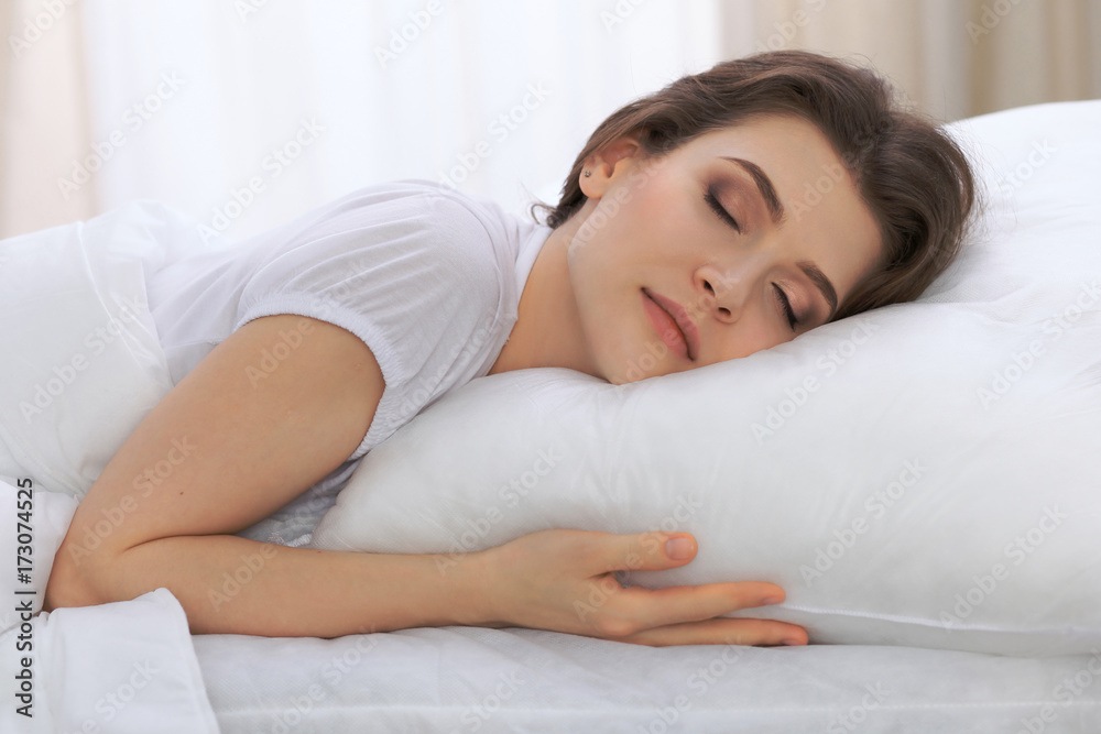 Beautiful young woman sleeping while lying in her bed and relaxing comfortably. It is easy to wake up for work or the day off. Concept of pleasant and rest reinstatement for active life Beautiful young woman sleeping while lying in her bed and relaxing comfortably. It is easy to wake up for work or the day off. Concept of pleasant and rest reinstatement for active life