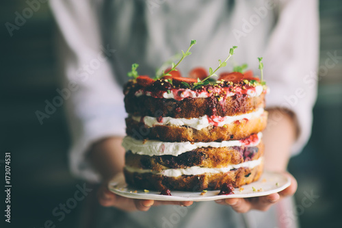 Delicious cake; naked cake with berries and whipped cream decorated with mint leaves