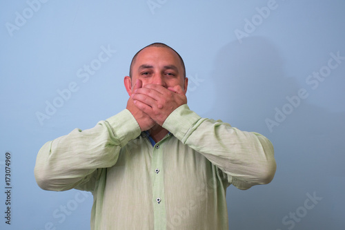 man covers his mouth with his hands, fear, does not want to roar, laughing photo