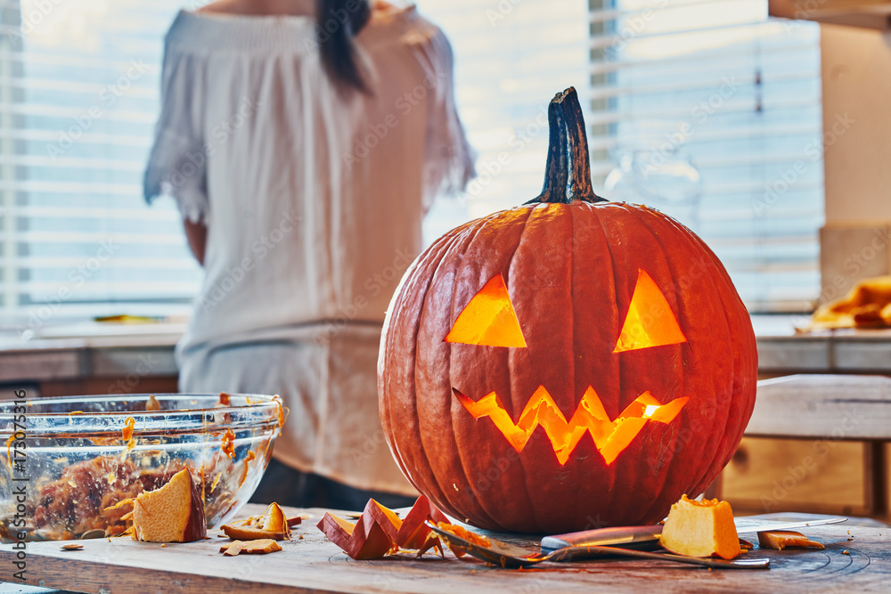 Naklejka premium cleaning up after making jack o lantern pumpkin for halloween on kitchen table