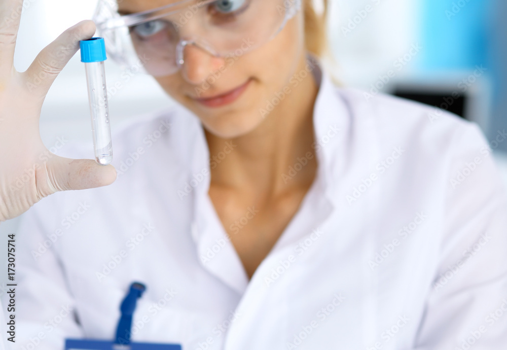 Female scientific researcher in laboratory studying substances or blood sample. Medicine and science concept Female scientific researcher in laboratory studying substances or blood sample. Medicine and science concept