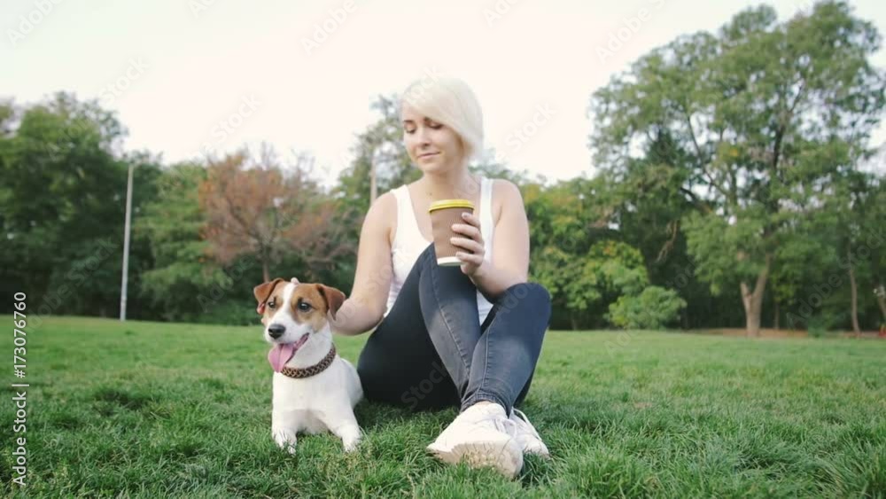 Young woman with little cute jack russel terrier in park