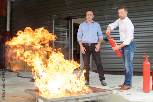 businessman using fire extinguisher during fire training