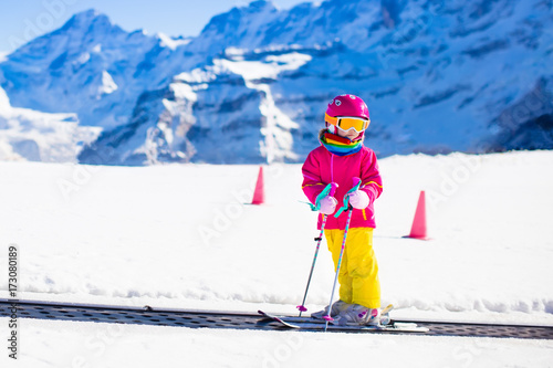 Child in ski school. Snow winter fun in mountains.