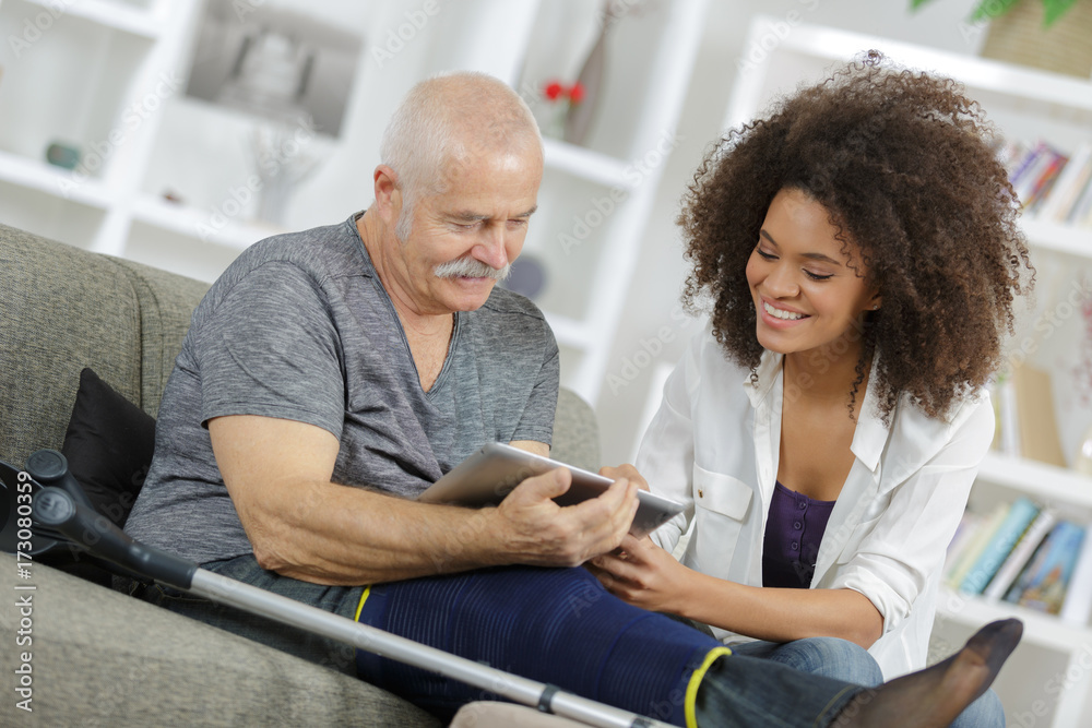 young woman and senior man chating with family using tablet young woman and senior man chating with family using tablet