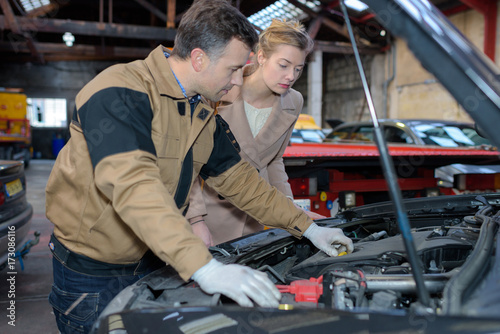 an auto mechanic and female customer in garage
