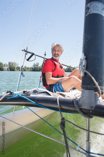 handsome mature man sailing on a lake © auremar