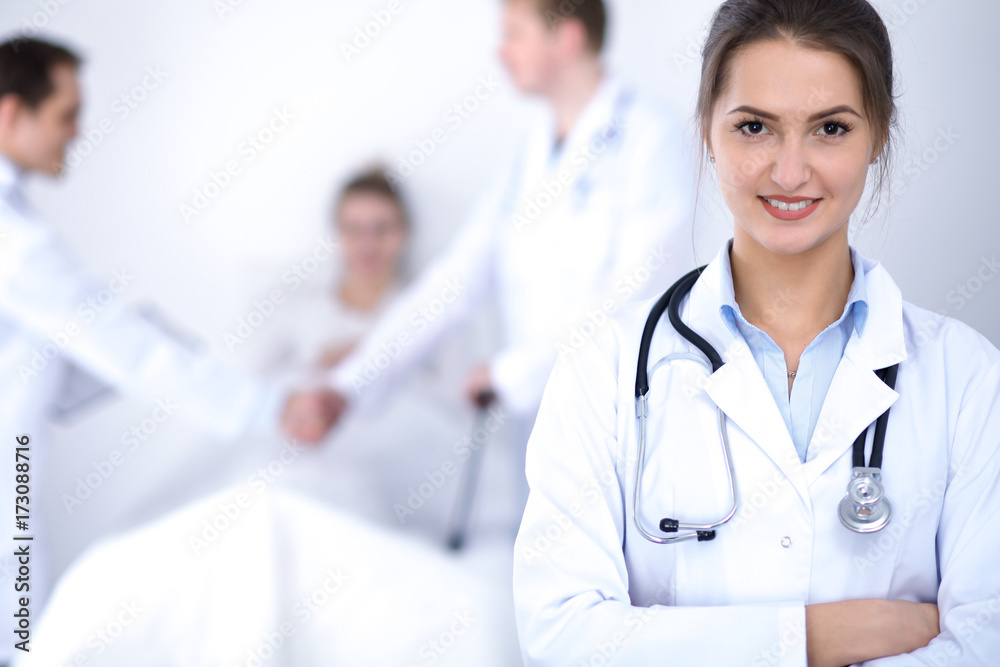 Female doctor smiling on the background with patient in the bed Female doctor smiling on the background with patient in the bed