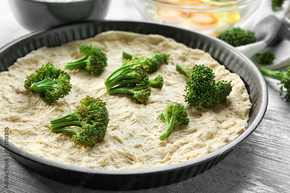 Uncooked broccoli quiche on wooden table Uncooked broccoli quiche on wooden table