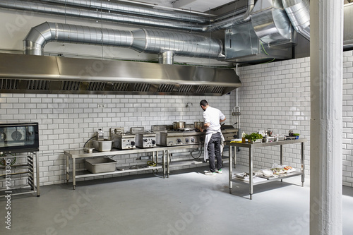 Male Chef Cooking In Professional Kitchen