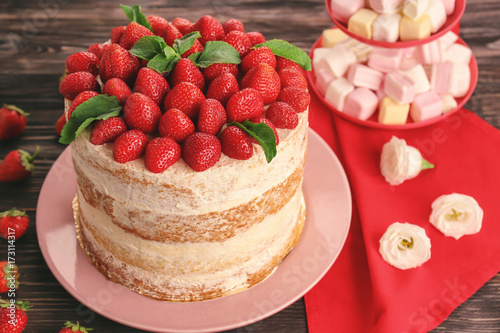 Delicious cake decorated with strawberries on plate