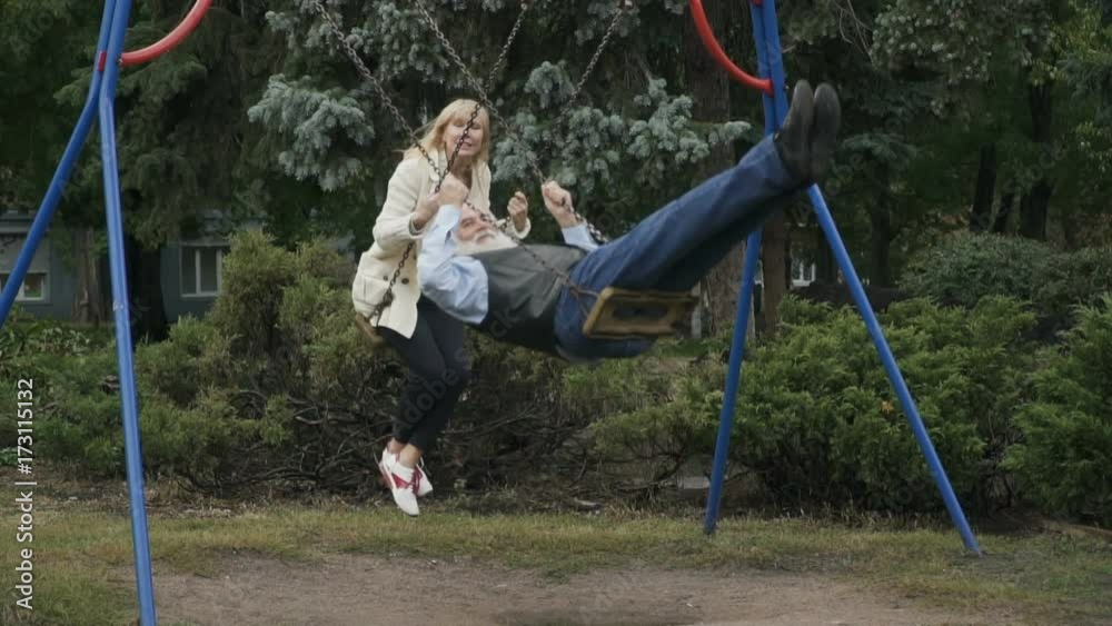Two adult people swings in slowmotion Two adult people swings in slowmotion