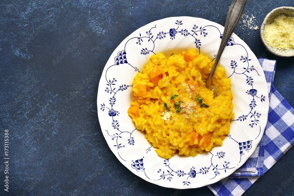 Spicy pumpkin risotto with garlic,thyme and parmesan cheese.Top view. Spicy pumpkin risotto with garlic,thyme and parmesan cheese.Top view.