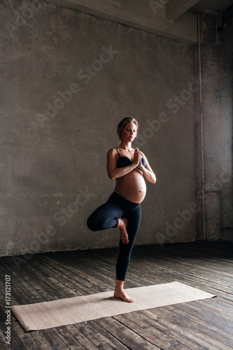 Young beautiful pregnant yoga posing in studio