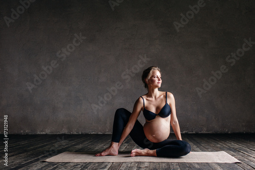 Young beautiful pregnant yoga posing in studio