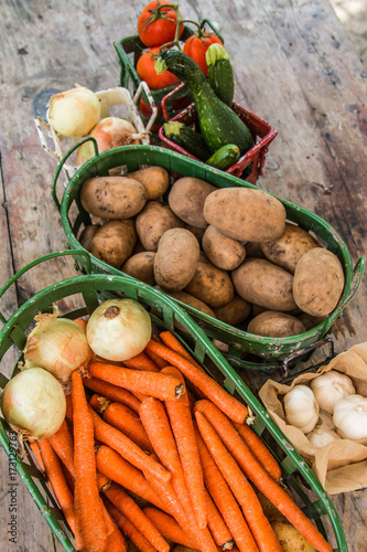 Vegetables in metal baskets on distressed vintage wood background 