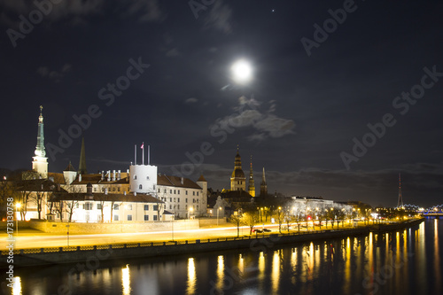 Night view of Old Riga with church towers with full moon shining above