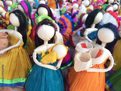 Many colorful artisian dolls on a mexican market cornbread make photo
