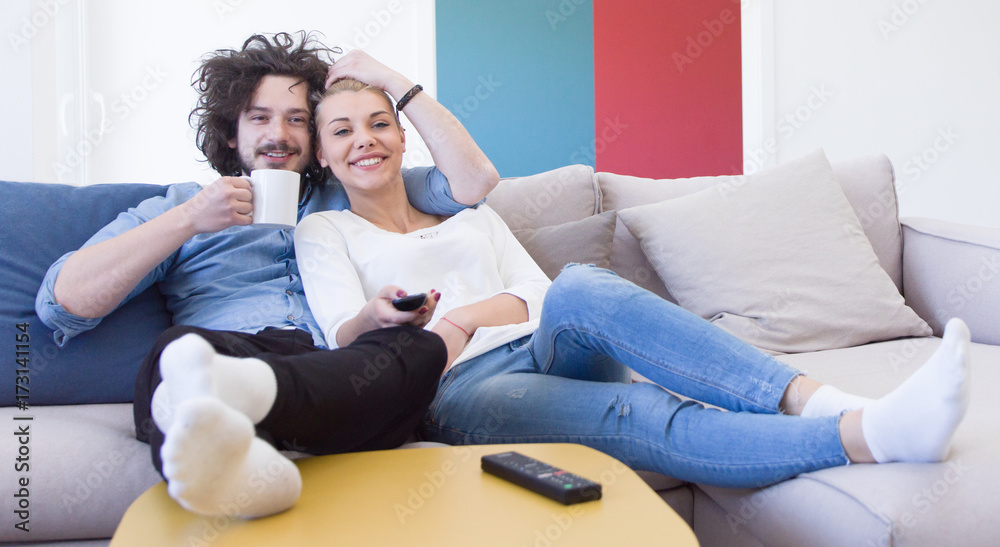 Young couple on the sofa watching television Young couple on the sofa watching television