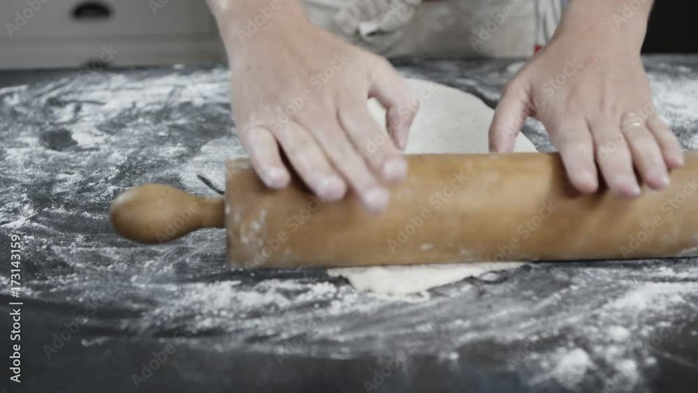Person uses pie roller on dough, close up Person uses pie roller on dough, close up