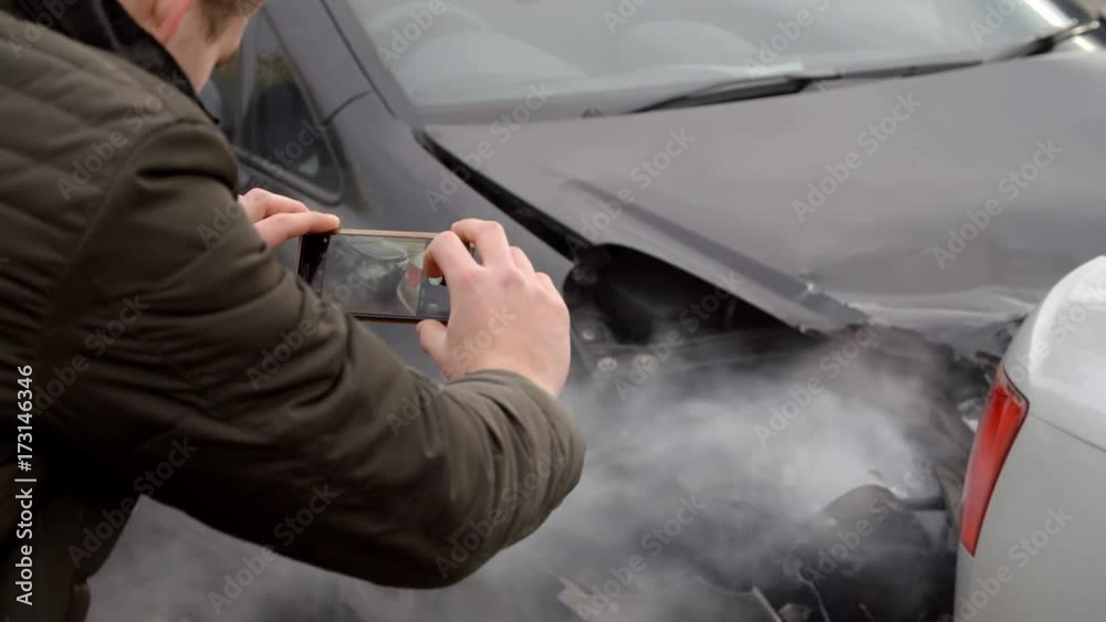 Man Taking Photo Of Car Accident On Mobile Phone