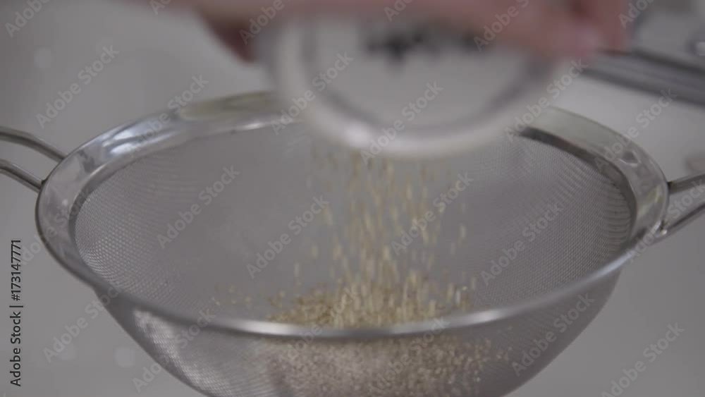 Chef pours couscous into strainer, close up Chef pours couscous into strainer, close up