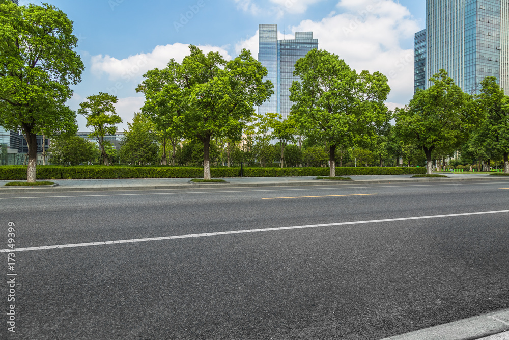 empty asphalt road near glass office building.