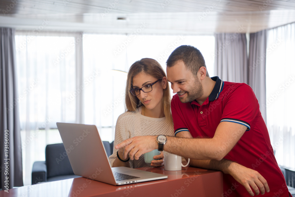 couple drinking coffee and using laptop at home couple drinking coffee and using laptop at home