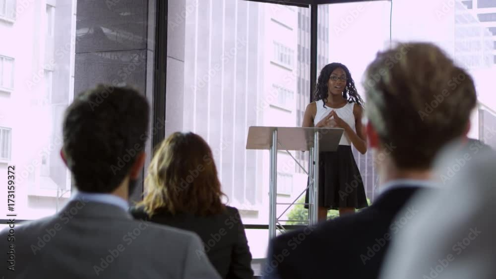 Young black woman presenting seminar to a business audience, shot on R3D