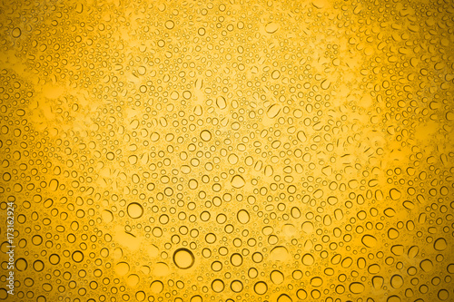 Water drops on yellow glass, Rain droplets on glass background.