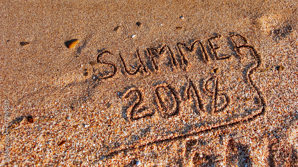 Fototapeta premium Summer 2018 written on the sea beach.Textured sandy template for New year greetings