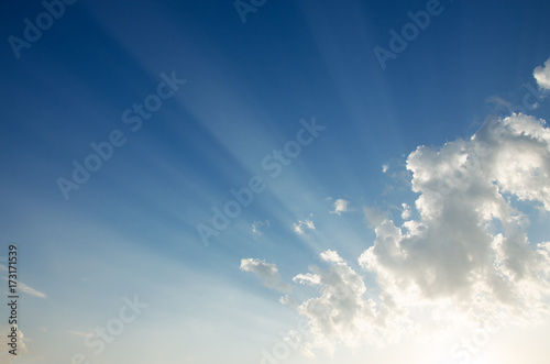 Blue sky background with beautiful bright clouds and sun beams.Summer cloudscape. 