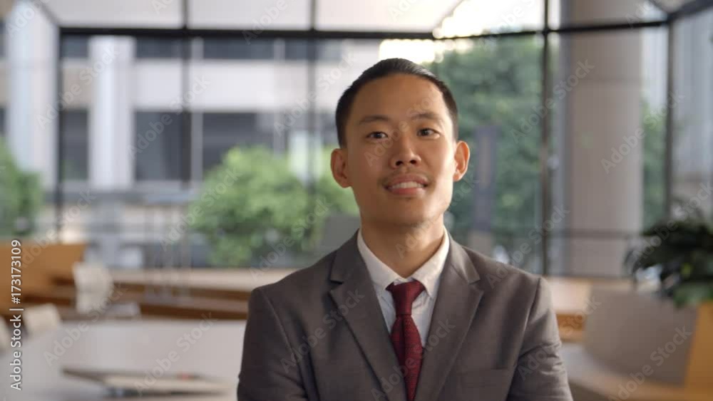 Young Asian businessman walking into focal plane Young Asian businessman walking into focal plane