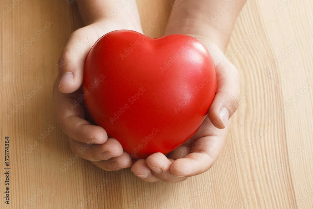 Heart in hand on wooden background Heart in hand on wooden background