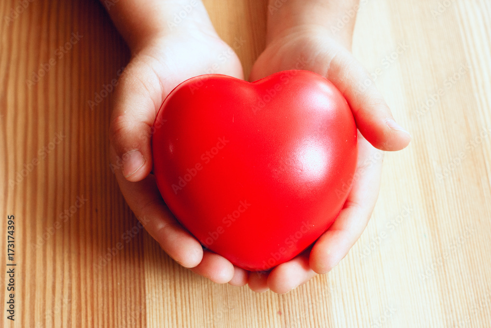 Heart in hand on wooden background Heart in hand on wooden background