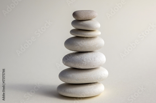 Harmony and balance, cairns, simple poise stones on white background, rock zen sculpture, white pebbles, single tower, simplicit