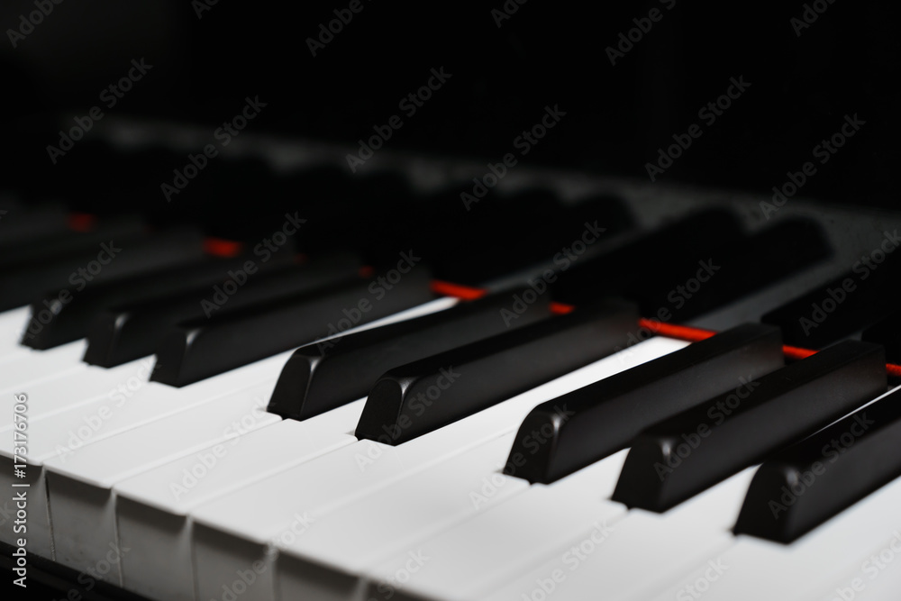 Piano keys on black classical grand piano - closeup for music