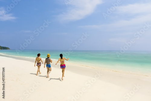 Three girls with bikini walking on the beach