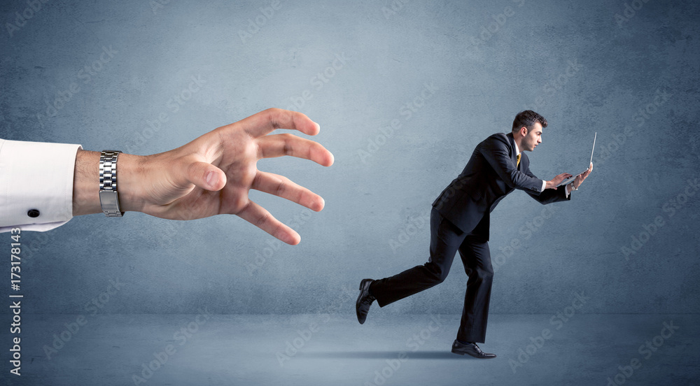 Businessman running from hand Businessman running from hand